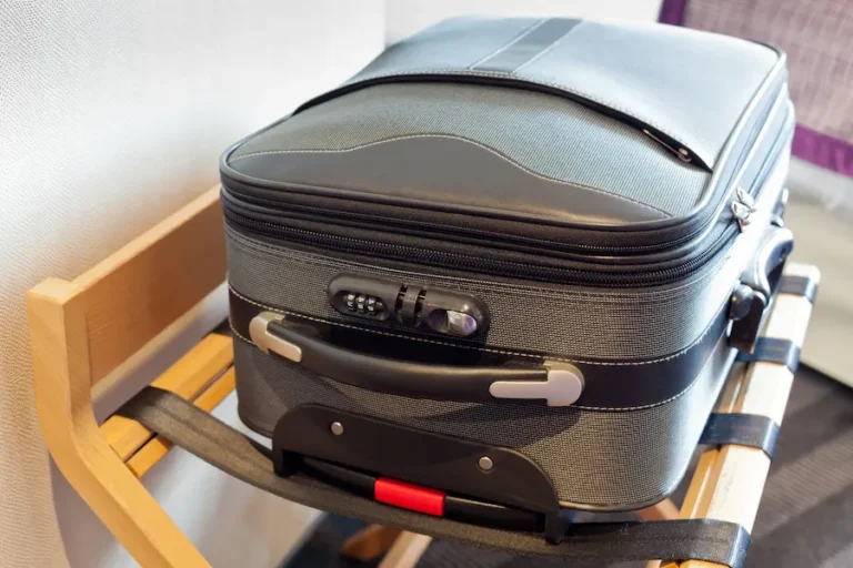 Suitcase sitting on a suitcase rack in a hotel room.