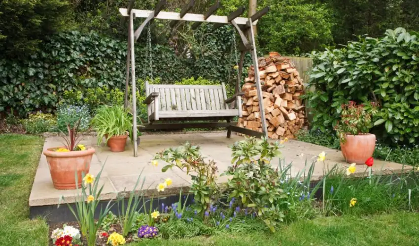 A swing bench in a backyard garden area. Find out how to prevent termites from entering your yard.