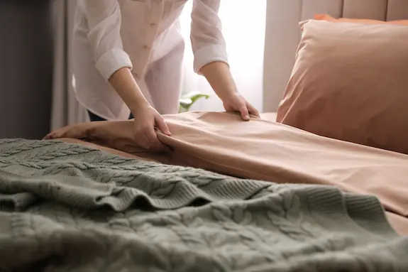Hands making the bed
