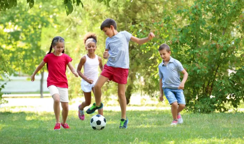 Children playing soccer in the yard after effective mosquito treatment by Action Pest Control.