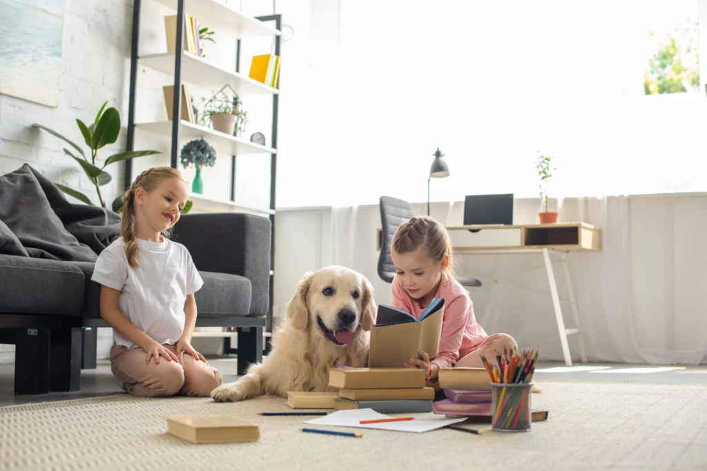 Children playing on the floor in there home with the family dog.